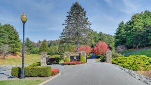A driveway leading to a gated entrance with a stone wall and a sign. - Blue Ridge Mountain Golf Resort Home w/ Views! (Roaring Gap)