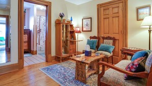 A traditional living room with a wooden coffee table, two upholstered chairs, a wooden cabinet, and a patterned rug. - 'dragons Roost' Cabin w/ Sangre de Cristo Views! (Florissant)