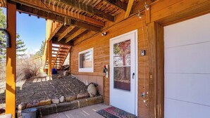 A wooden cabin with a covered porch, a door with a window, and a welcome mat. - 'dragons Roost' Cabin w/ Sangre de Cristo Views! (Florissant)