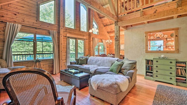 A cozy cabin interior with a large wooden ceiling, a sectional sofa, a dining table, and a green chest of drawers. - Game Room & Hot Tub: Pet-friendly Mount Snow Gem (West Dover)