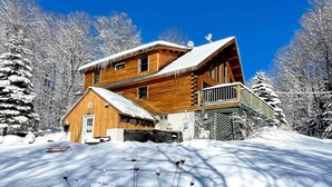 A wooden cabin with a balcony, surrounded by snow-covered trees. - Game Room & Hot Tub: Pet-friendly Mount Snow Gem (West Dover)