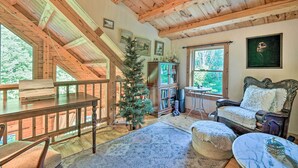 A cozy cabin interior with a wooden ceiling, a Christmas tree, a fireplace, a sofa, and a dining table. - Game Room & Hot Tub: Pet-friendly Mount Snow Gem (West Dover)