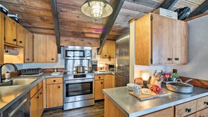 A modern kitchen with wooden cabinets, stainless steel appliances, and a central island. - Big Sky Condo w/ Resort Amenities & Mountain Views (Big Sky)