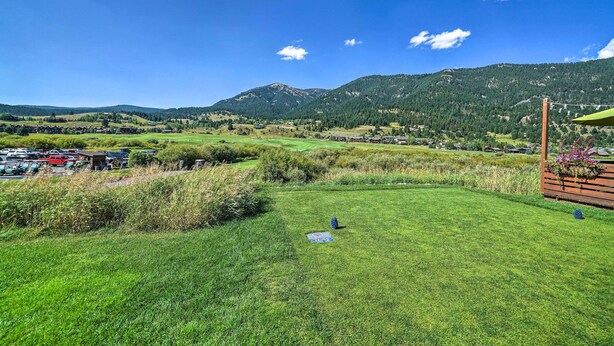 A grassy field with a wooden structure and a view of a mountainous landscape. - Big Sky Condo w/ Resort Amenities & Mountain Views (Big Sky)