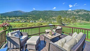 A deck with wicker furniture and a view of a golf course and mountains. - Big Sky Condo w/ Resort Amenities & Mountain Views (Big Sky)