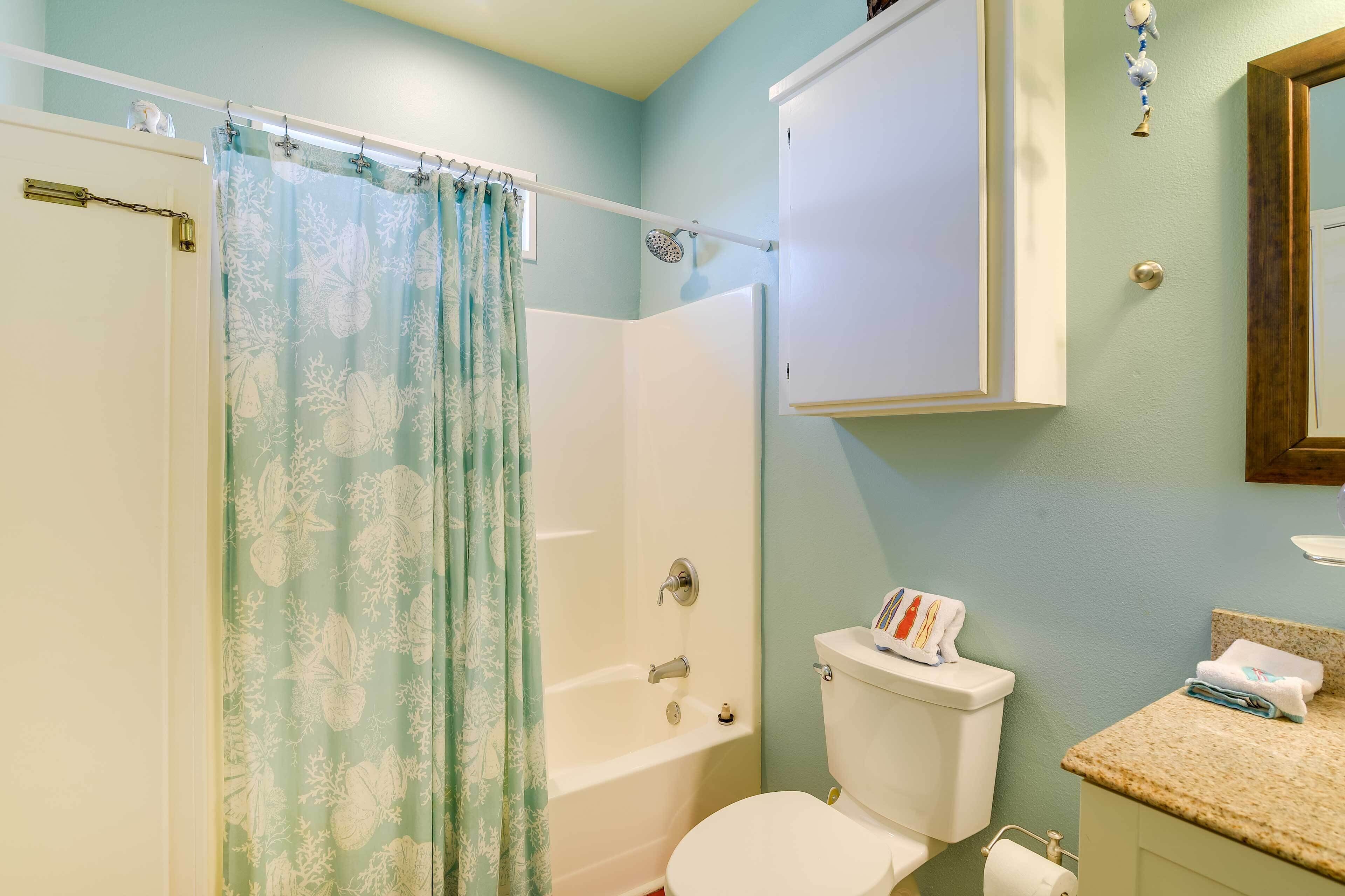 Ein Badezimmer mit Duschvorhang, Badewanne, Toilette und Waschbecken.