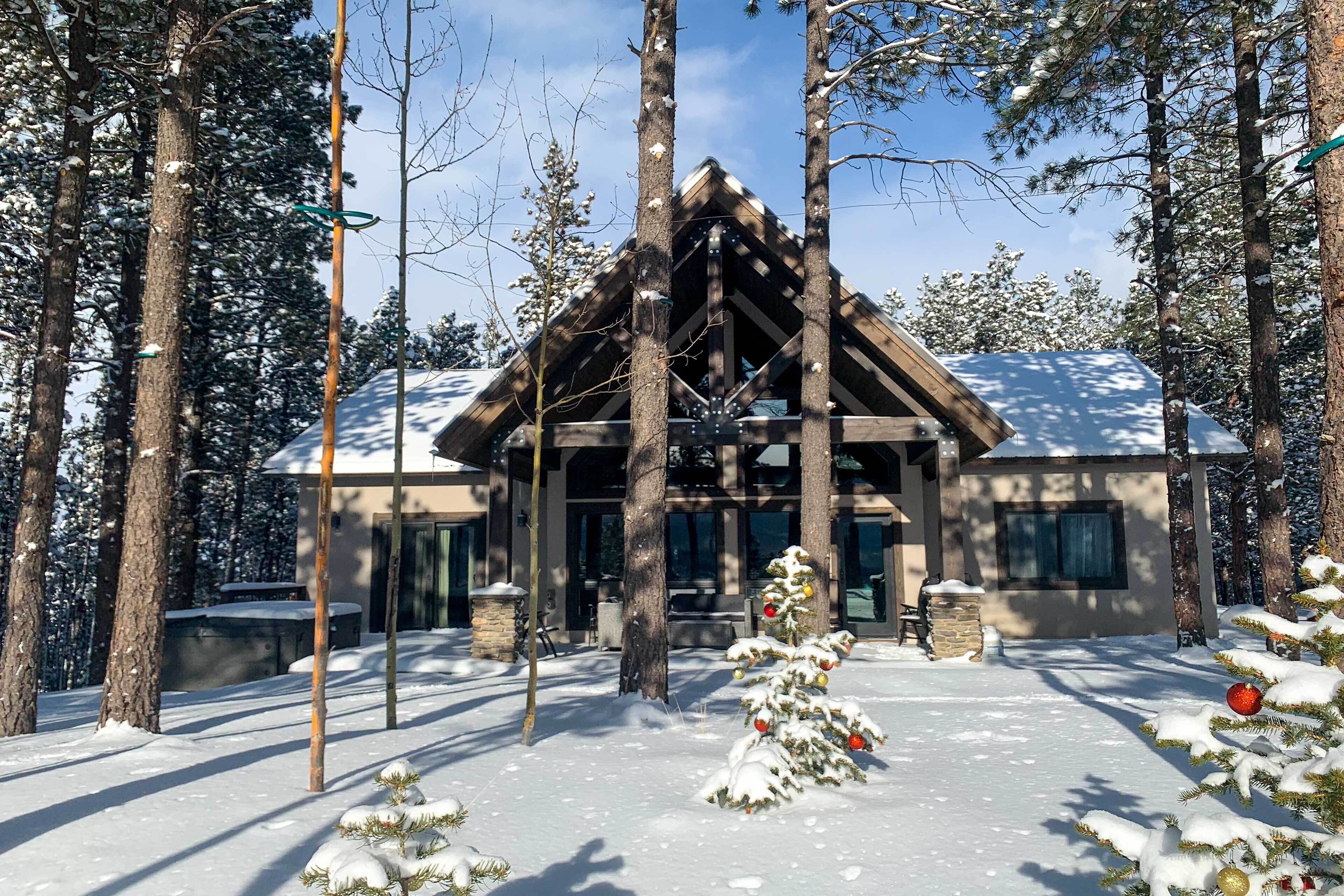 Een houten lodge, omgeven door met sneeuw bedekte bomen.