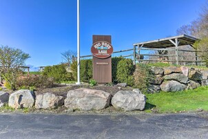 A sign for Big Bass Lake Community Association with a wooden structure in the background.