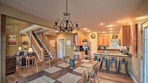 A spacious kitchen with a central island, wooden flooring, and a dining area with a large wooden table and chairs.