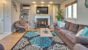 Ein Wohnzimmer mit Kamin, einer Couch, einem Couchtisch und einem dekorativen Teppich.