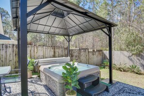 A covered outdoor hot tub area with a pergola, a seating area, and a wooden fence in the background. - Orange Beach Home w/ Hot Tub < 2 Mi to The Wharf (Orange Beach)