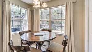 A dining area with a round wooden table, six chairs, and two pendant lights. - Orange Beach Home w/ Hot Tub < 2 Mi to The Wharf (Orange Beach)