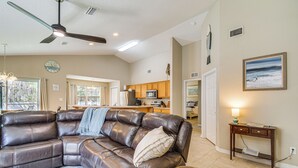 A spacious living room with a large leather sectional sofa, a wooden coffee table, and a ceiling fan. - Orange Beach Home w/ Hot Tub < 2 Mi to The Wharf (Orange Beach)