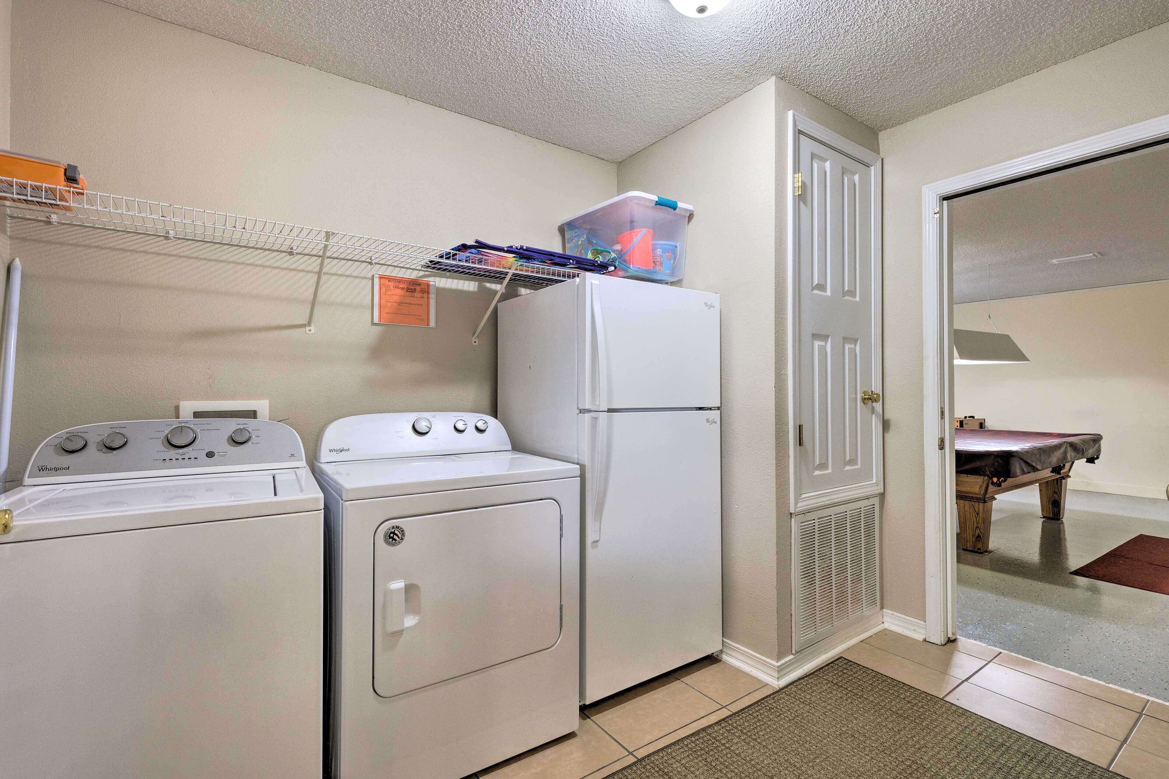 A laundry room with a washer, dryer, and refrigerator.