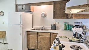 A compact kitchen with a refrigerator, double sink, wooden cabinets, and a stove. - Highplaines Haven w/ Views, Hunting & Fishing! (Long Lake)