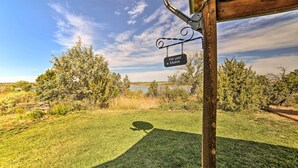 Skilt med teksten 'The Lake Cabin' i et naturområde med græs og træer.