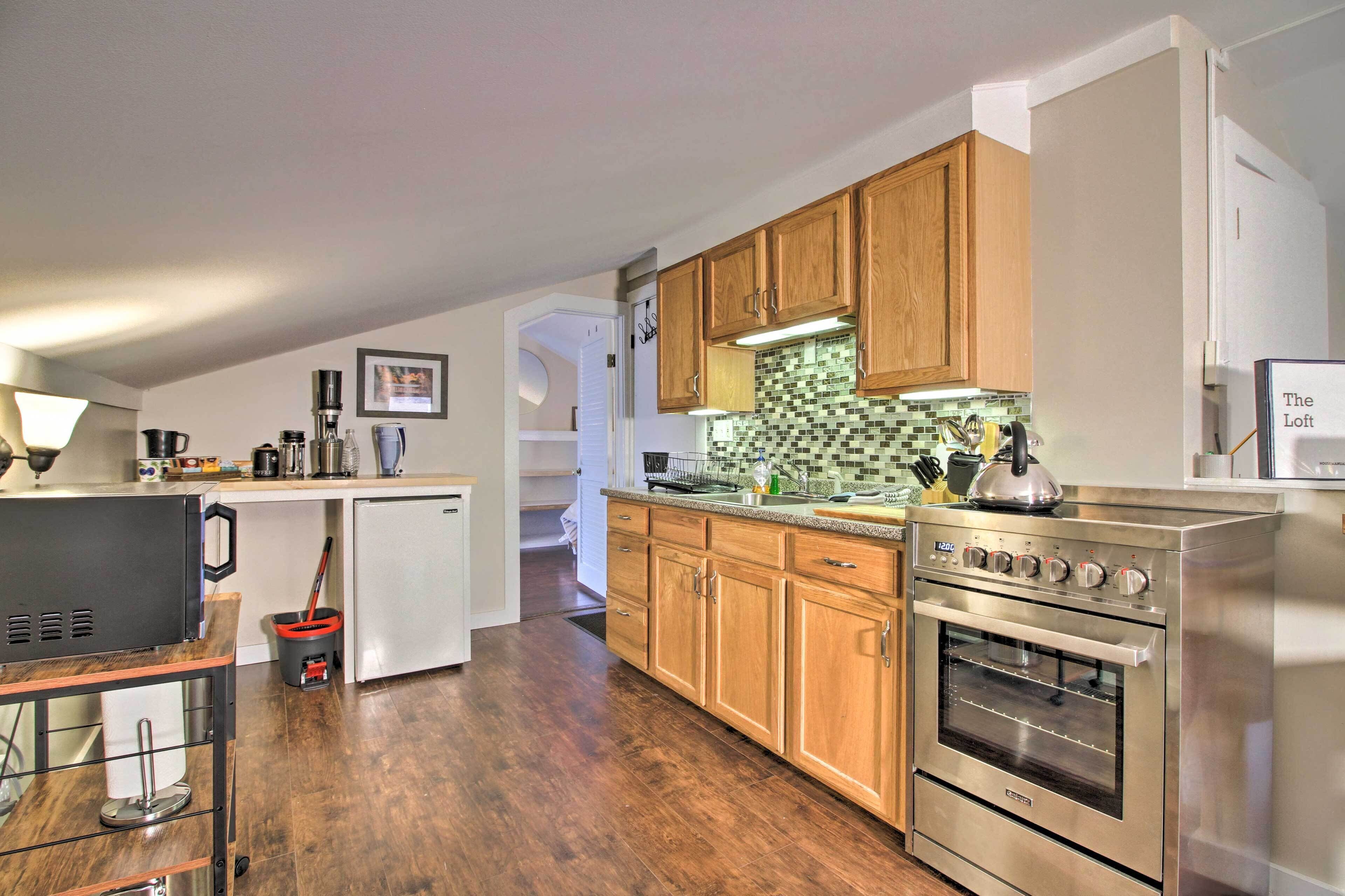 A modern kitchen with wooden cabinets, a stainless steel oven, and a tiled backsplash.