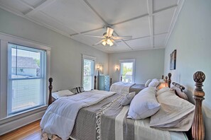 A bedroom with two beds, a ceiling fan, and a nightstand with a lamp. - Home w/ Patio, 2 Blocks to St. Lawrence River (Clayton)