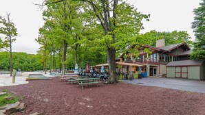 A lodge with outdoor seating and a large tree in front. - Lake Harmony Villa: Walk to Big Boulder Mountain! (Lake Harmony)