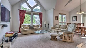 A spacious living room with a high ceiling, large windows, and a cozy seating area. - Lake Harmony Villa: Walk to Big Boulder Mountain! (Lake Harmony)