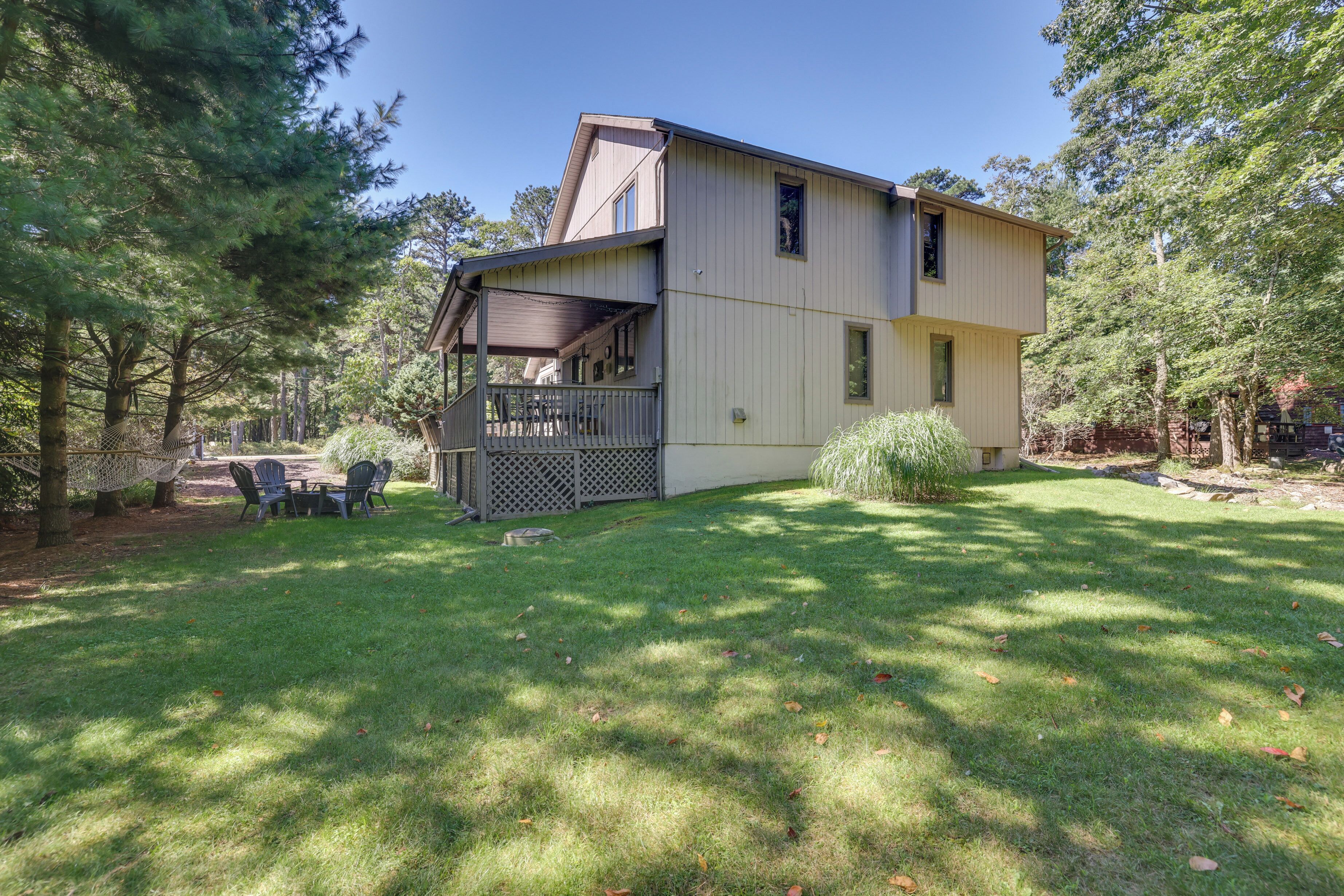 A two-story house with a covered porch and a small deck.