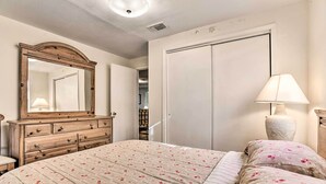 A bedroom with a bed, dresser, mirror, and wardrobe.