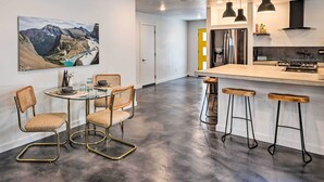 A modern kitchen with a central island, bar stools, and pendant lighting. - Modern Missoula Home ~ 2 Miles to Downtown! (Missoula)
