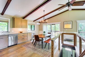 Uma cozinha moderna com vigas de madeira, uma área de jantar com um banco e vista para o exterior.