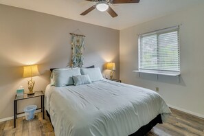 A bedroom with a bed, two bedside lamps, a ceiling fan, a wall hanging, and a window with blinds. - Mom's Place in Jemez - 1 Mi to Hot Spring (Jemez Springs)