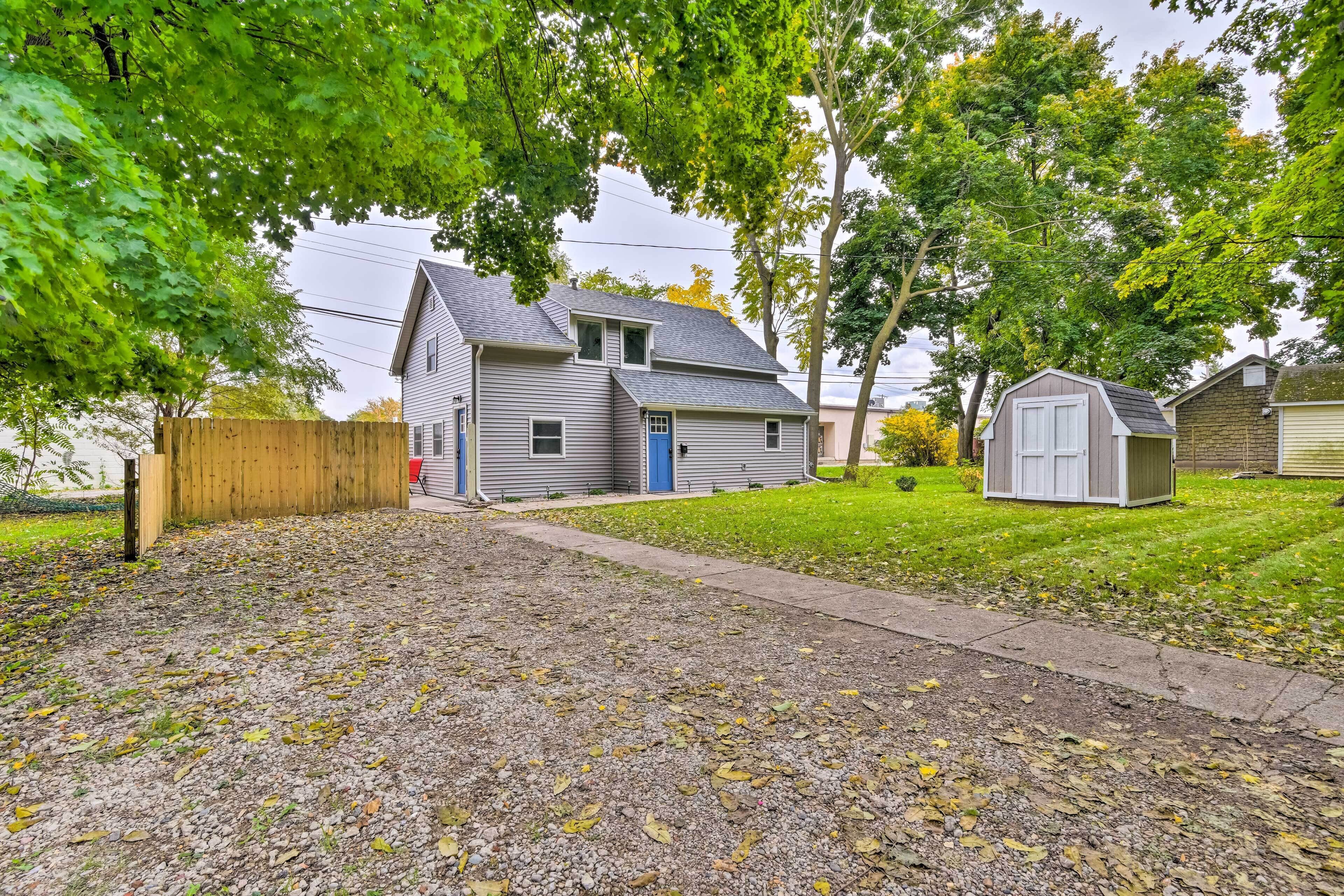 A residential property with a two-story house, a detached garage, and a small shed.