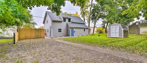 A residential property with a two-story house, a detached garage, and a small shed.