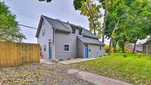 A two-story house with a front yard, a wooden fence, and a driveway. - Centrally Located Mount Pleasant Retreat! (Mount Pleasant)
