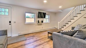 A spacious living room with hardwood flooring, a grey sofa, a coffee table, and a staircase leading to an upper level. - Centrally Located Mount Pleasant Retreat! (Mount Pleasant)