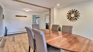 A conference room with a wooden table and four chairs, a decorative wall piece, and a coat rack. - Centrally Located Mount Pleasant Retreat! (Mount Pleasant)