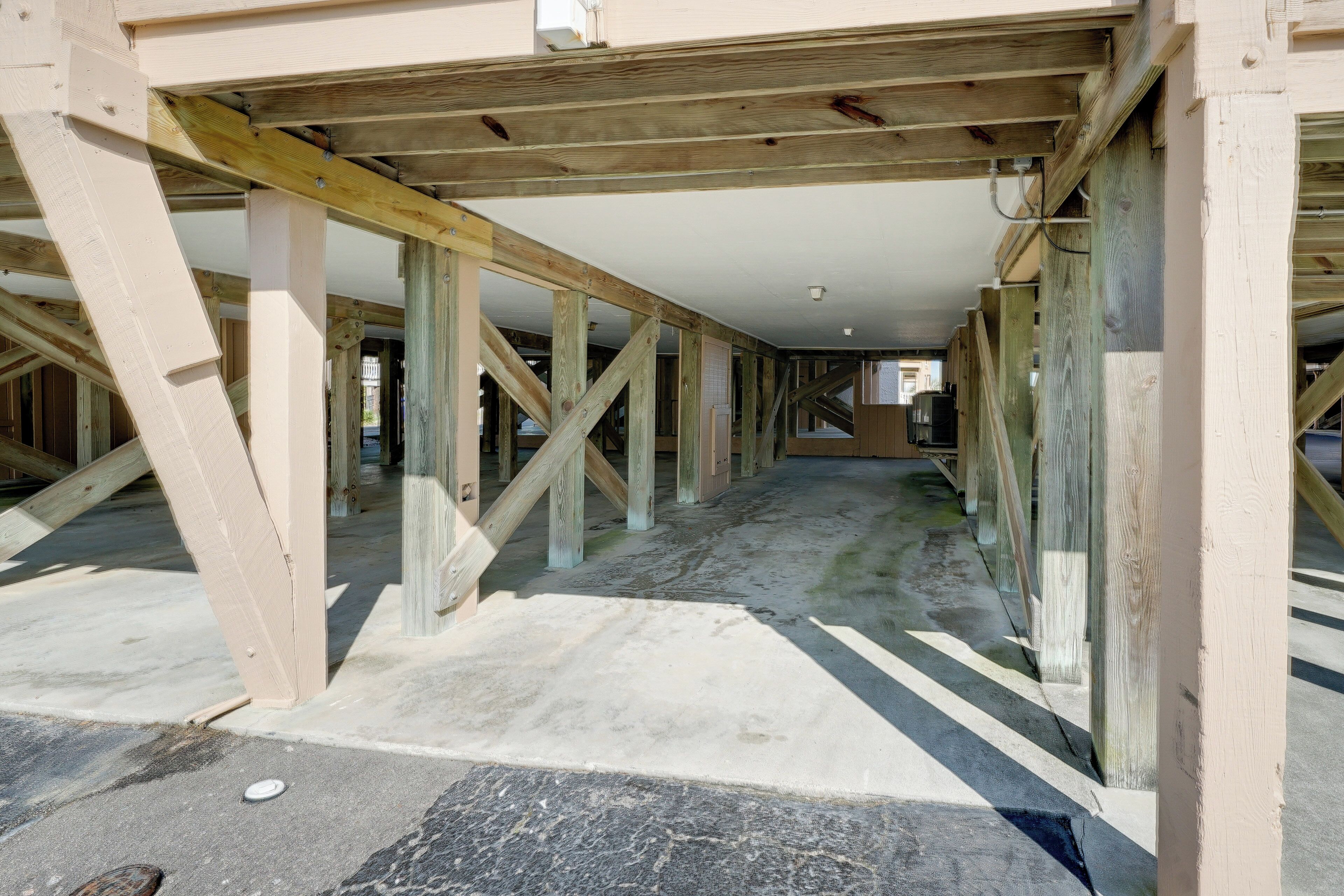 Vue intérieure d’un bâtiment en construction, avec des poutres en bois apparentes et des planchers en béton non finis.