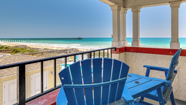 A balcony with a view of the ocean, a pier, and beach. - Ocean Views + Resort Pool! N Topsail Beach Condo (Sneads Ferry)