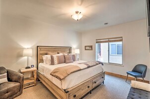 Un dormitorio con cama de madera, una mesita de noche, una silla y una ventana con persianas.