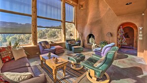 A spacious living area with large windows, a fireplace, and comfortable seating. - Peaceful New Mexico Retreat w/ Panoramic Mtn Views (Cleveland)