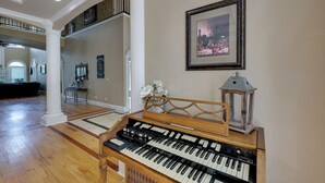 A spacious living area with a grand piano, a decorative lantern, and a framed artwork on the wall. - Game Room & Private Pool: Home in Hot Springs! (Hot Springs)