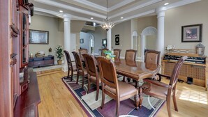 A dining room with a large wooden table, six chairs, and a chandelier. - Game Room & Private Pool: Home in Hot Springs! (Hot Springs)