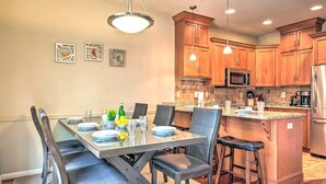 A modern kitchen with wooden cabinets, a granite countertop, and stainless steel appliances. - Community Perks & Deck: Lake Harmony Townhome! (Lake Harmony)