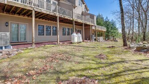 A two-story house with a covered porch and a large yard. - Community Perks & Deck: Lake Harmony Townhome! (Lake Harmony)