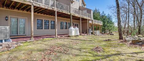 A two-story house with a covered porch and a large yard.