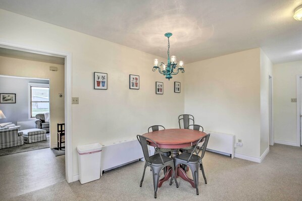 A dining area with a round table and four chairs, a chandelier, and framed pictures on the wall. - Lovely Thermopolis Home < 3 Mi to Hot Springs (Thermopolis)