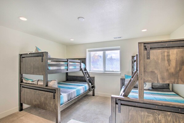 A room with bunk beds, a window, and a ceiling light.