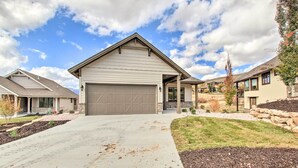 A residential house with a garage, driveway, and landscaped yard.