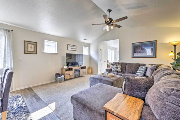 A living room with a gray sofa set, a wooden coffee table, and a ceiling fan. - Prismatic Boise Retreat w/ Fenced Backyard! (Boise)