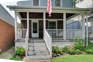 A two-story house with a front porch, a brick exterior, and a small garden with flowers. - Pittsburgh Home Near Frick Park, 7 Mi to Dtwn (Pittsburgh)