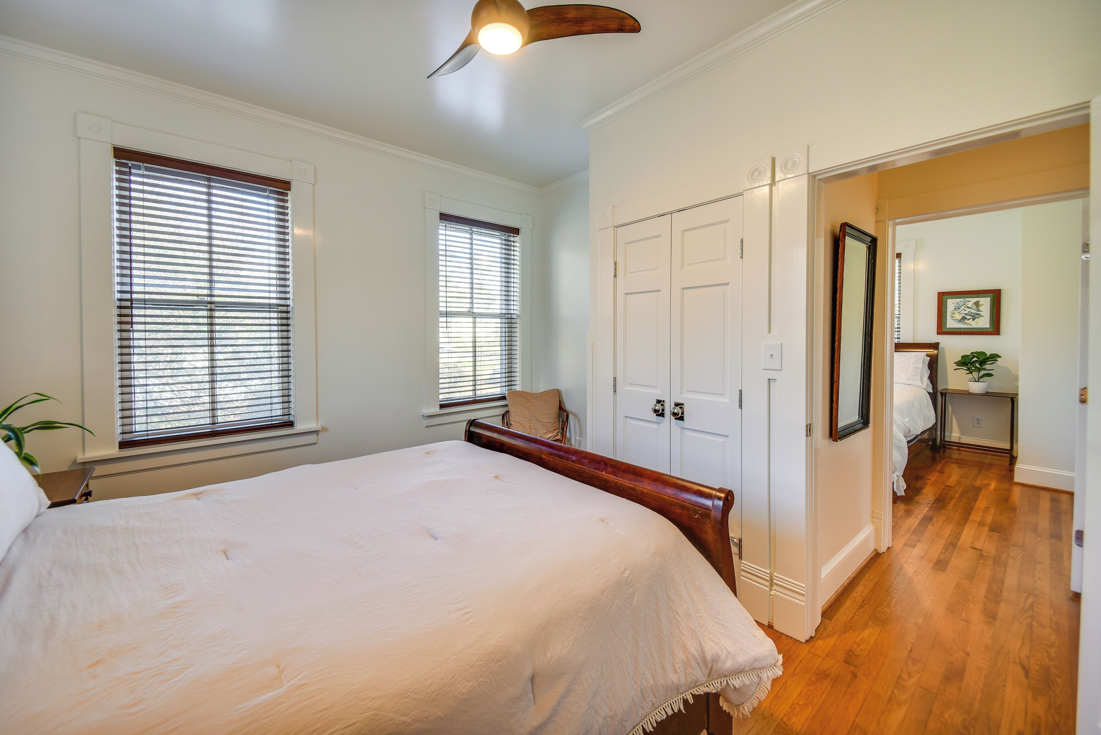 A bedroom with a large bed, a wooden headboard, and a white door.