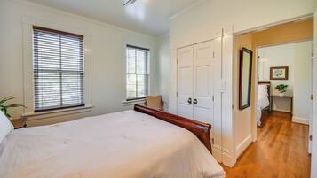 A bedroom with a large bed, a wooden headboard, and a white door.